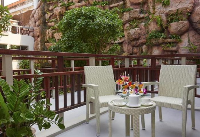 Balcony at The Agate Pattaya Boutique Resort, a gay-friendly hotel. Table with tea and fruit. Relaxing spot for gay travelers.