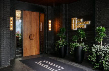 The Anndore House, part of JVD by Hyatt. Entrance of gay-friendly hotel with wooden door, plants, and sign. Toronto travel advice.