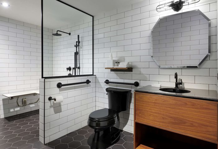 The Anndore House, part of JVD by Hyatt, bathroom. Gay-friendly hotel with black fixtures, white subway tile, and accessible shower.