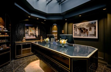 The Anndore House, part of JVD by Hyatt, a gay-friendly hotel. Lobby with a dark desk, flowers, and art. Great for gay men travel.
