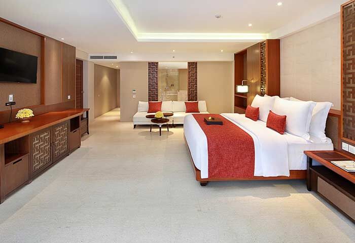 The Bandha Hotel & Suites room. Gay-friendly hotel with a king bed, couch, and TV. Luxury suite for gay men's travel. Modern interior design.