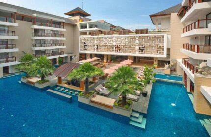 The Bandha Hotel & Suites, a gay-friendly hotel. View of the pool, palm trees, and lounge area. A luxurious travel destination.