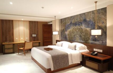 The Bandha Hotel & Suites, a gay-friendly hotel. Modern room with king bed, desk, and marble accent wall. Ideal for gay travel in Bali.
