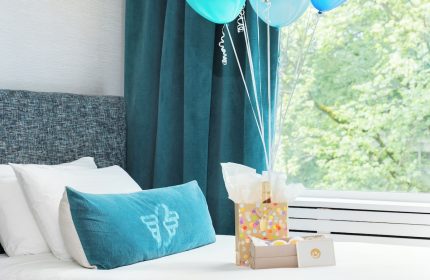 Gay-Friendly Hotel The Burrard Hotel room with balloons, gifts on a bed. A welcoming scene for LGBTQ+ travelers. Vancouver hotel.