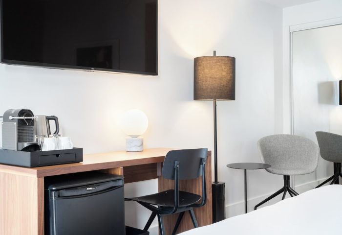 The Burrard Hotel room detail. Gay-friendly hotel with desk, chair, mini fridge, coffee maker, and lamps. Modern design for gay men travel.