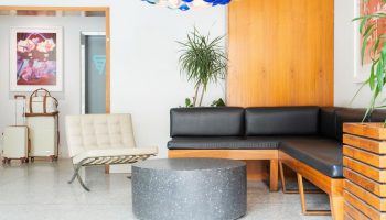 The Burrard Hotel's stylish lobby. Gay-friendly hotel with modern design, seating area, and luggage. Ideal for gay men travel in Vancouver.