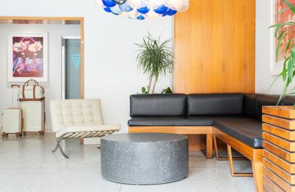 The Burrard Hotel's stylish lobby. Gay-friendly hotel with modern design, seating area, and luggage. Ideal for gay men travel in Vancouver.