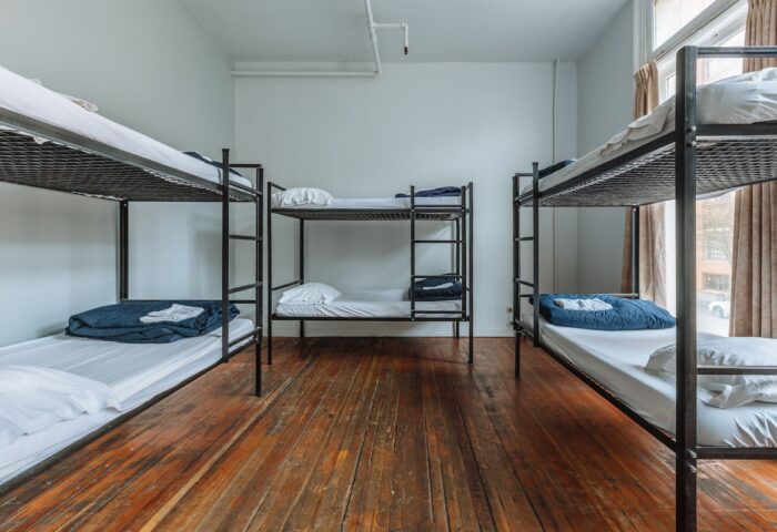 Dorm room at The Cambie Hostel Gastown, a gay-friendly hotel. Features bunk beds, hardwood floors, and natural light. Budget travel lodging.