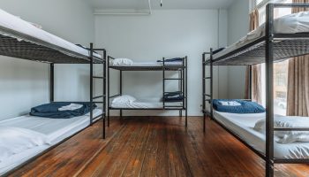 Dorm room at The Cambie Hostel Gastown, a gay-friendly hotel. Features bunk beds, hardwood floors, and natural light. Budget travel lodging.