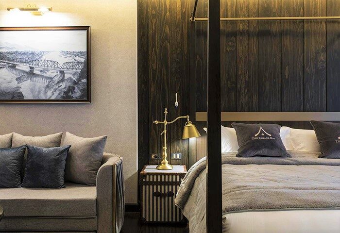 Chiang Mai Old Town Hotel room. Gay-friendly hotel's interior with a bed, couch, and bridge art. A comfortable stay for gay travelers.