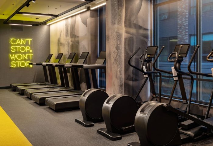 Gym at The Clancy Autograph Collection, a gay-friendly hotel. Treadmills and ellipticals are available for guests' use. Can't stop, won't stop neon.