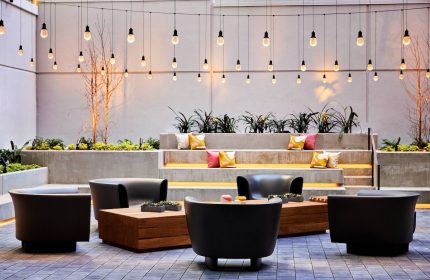 The Clancy Autograph Collection gay-friendly hotel outdoor lounge area with string lights, chairs, and tiered seating. Great for gay travelers.
