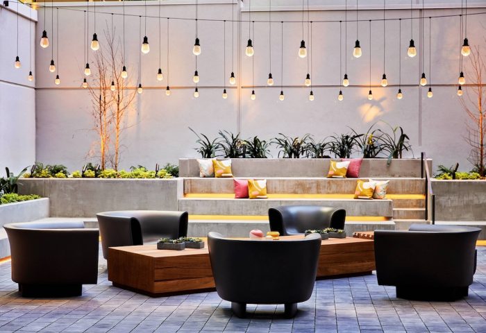 The Clancy Autograph Collection gay-friendly hotel outdoor lounge area with string lights, chairs, and tiered seating. Great for gay travelers.