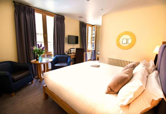The Clarence, a gay-friendly hotel: Bedroom with double bed, seating area, desk, and TV. A comfortable space for gay men travelers.