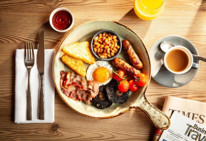 Breakfast at The Clermont London Charing Cross, a gay-friendly hotel. Full English breakfast with eggs, bacon, sausage, beans, and coffee.