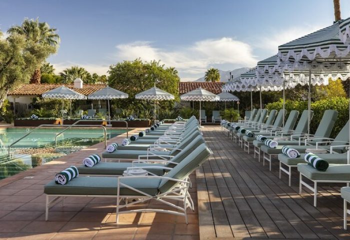 Poolside at The Colony Palms Hotel, a gay-friendly hotel. Loungers and umbrellas offer relaxation. Perfect for gay travel in Palm Springs.