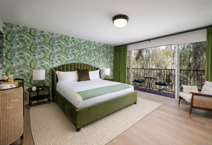 Gay-Friendly The Colony Palms Hotel room. Green tropical wallpaper, bed, and balcony. A great hotel for gay men's travel and vacations.