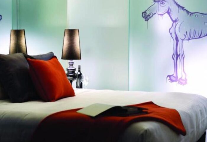 The Cullen Melbourne Art Series hotel room. Gay-friendly hotel with modern art, lamps, pillows, and bed. Great for gay travel in Melbourne.