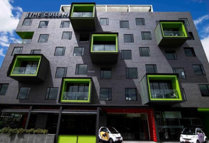 The Cullen Melbourne Art Series, a gay-friendly hotel. Unique architecture, with boxy balconies and two Smart cars parked outside.
