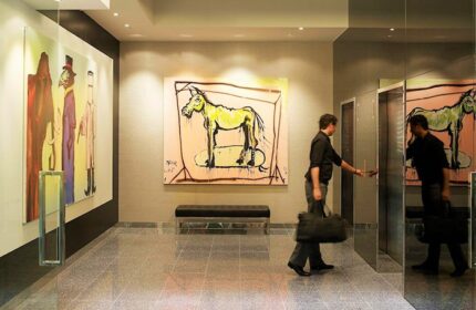 The Cullen Melbourne Art Series gay-friendly hotel: lobby with art, man entering elevator. Upscale travel advice for gay men.