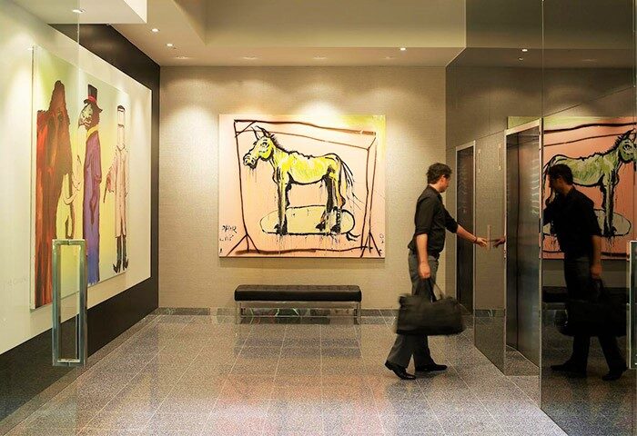 The Cullen Melbourne Art Series gay-friendly hotel: lobby with art, man entering elevator. Upscale travel advice for gay men.