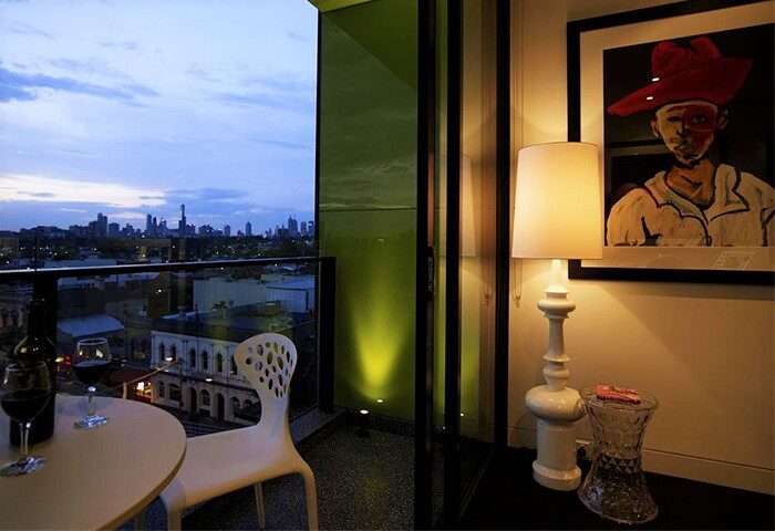 Balcony view at The Cullen, Melbourne's gay-friendly Art Series hotel. Wine, city skyline, & unique art create a welcoming atmosphere for travelers.