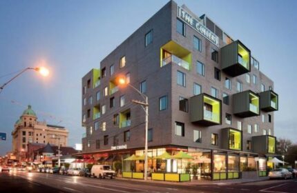 The Cullen Melbourne Art Series Hotel exterior. Gay-friendly hotel with unique architecture. Melbourne travel. Modern design with green accents.