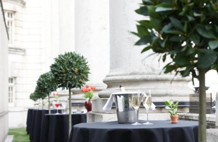 The Dilly, a gay-friendly hotel. Champagne flutes and ice bucket on tables, set for an event at The Dilly hotel. Gay men travel advice.