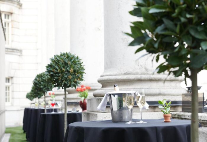 The Dilly, a gay-friendly hotel. Champagne flutes and ice bucket on tables, set for an event at The Dilly hotel. Gay men travel advice.