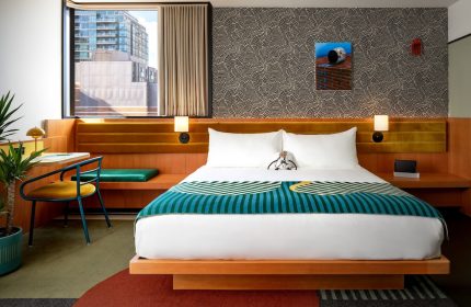 The Drake Hotel room. Gay-friendly hotel with bed, desk, and city view. Modern design with bold patterns. Ideal for gay men's travel.