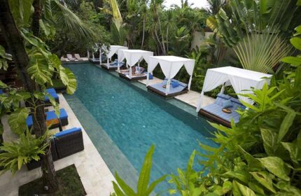The Elysian Boutique Villa Hotel pool in Bali. Gay-friendly hotel with cabanas over the water. Tropical paradise for gay men's travel.