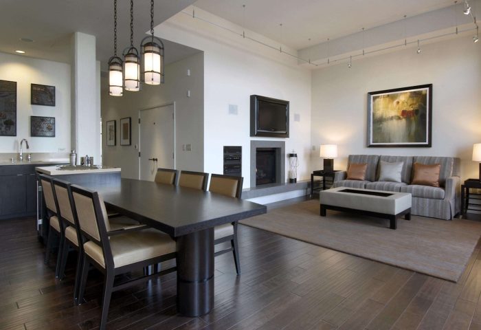 Fairmont Heritage Place Ghirardelli Square suite. Gay-friendly hotel living room with dining table, fireplace, and sofa. Modern design.