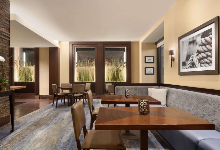 The Fairmont Heritage Place Ghirardelli Square's dining area. A gay-friendly hotel with tables, chairs, and nautical decor.