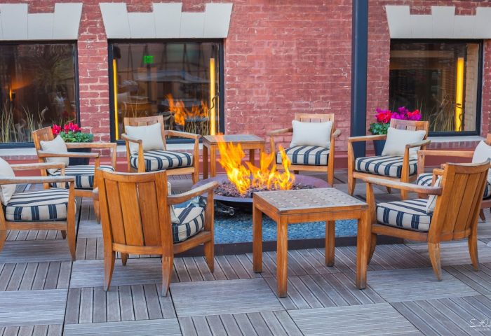 Fairmont Heritage Place Ghirardelli Square's outdoor patio with fire pit. Gay-friendly hotel seating area. San Francisco travel.