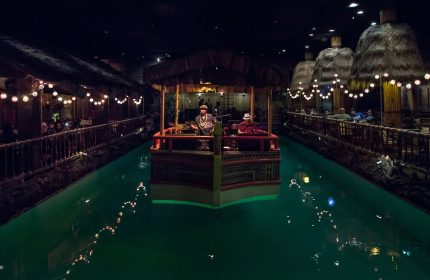 Fairmont San Francisco Hotel's Tonga Room: Gay-friendly hotel bar with live music on a boat in a pool. Tiki huts & string lights add to the vibe.