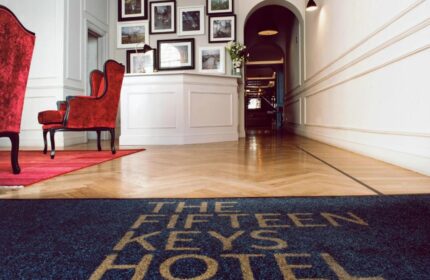 The Fifteen Keys Hotel lobby. Pet-friendly, gay-friendly hotel features elegant decor, wood floors, and a welcome mat. Red armchairs.