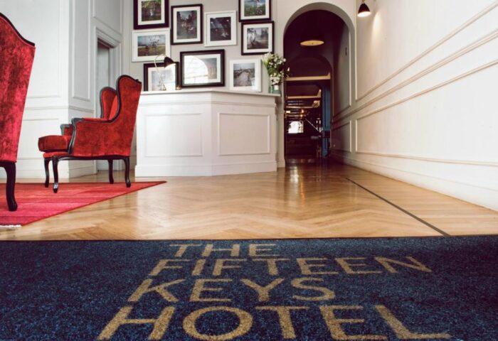The Fifteen Keys Hotel lobby. Pet-friendly, gay-friendly hotel features elegant decor, wood floors, and a welcome mat. Red armchairs.