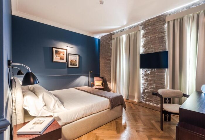 Bedroom at The Fifteen Keys Hotel, a gay-friendly and pet-friendly hotel. Features a bed, TV, brick wall, and stylish décor.