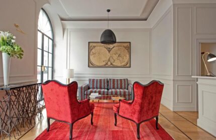 The Fifteen Keys Hotel lobby. Gay-friendly, pet-friendly hotel with red chairs, patterned sofa, and world map. Luxury travel for gay men.