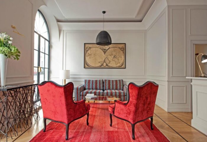 The Fifteen Keys Hotel lobby. Gay-friendly, pet-friendly hotel with red chairs, patterned sofa, and world map. Luxury travel for gay men.