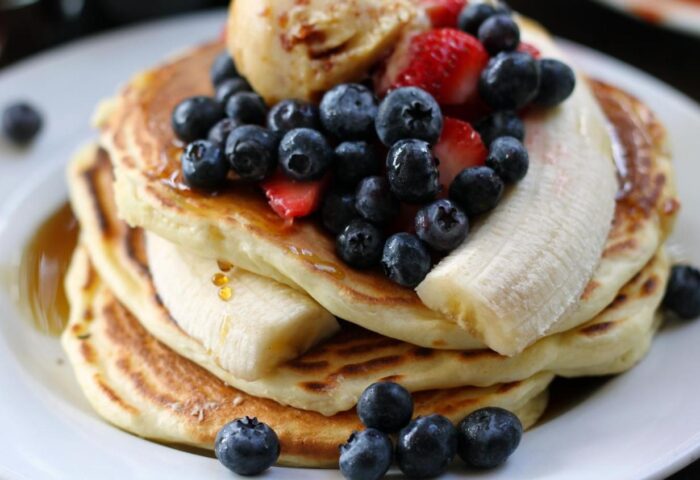 The Fleet: Stack of pancakes topped with blueberries, strawberries, banana, syrup, and a scoop of ice cream. Gay-friendly hotel breakfast.