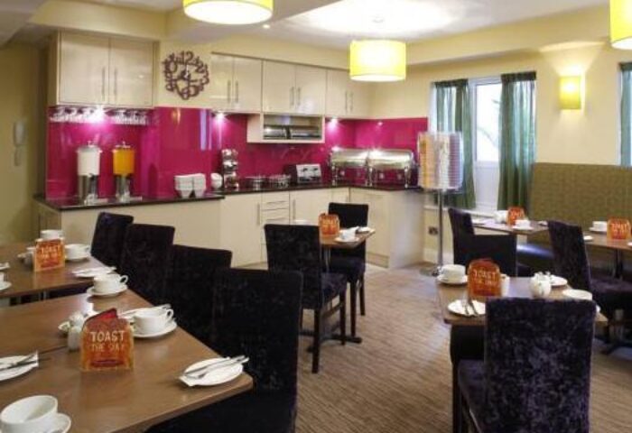 The Fleet Hotel's dining area with tables set for breakfast. This gay-friendly hotel offers a comfortable and welcoming atmosphere.