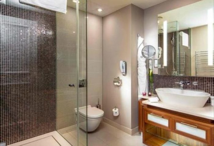 Bathroom at The Grand Mark Prague, a gay-friendly and pet-friendly Leading Hotels of the World. Features a modern shower, sink, and vanity.