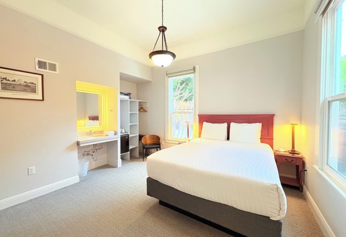 The Grove Inn, gay-friendly hotel room. Queen bed, sink, closet, chair, and window. Great for gay men's travel.