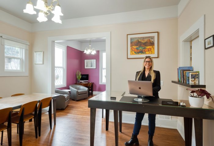 The Grove Inn, a gay-friendly hotel. Woman with laptop at reception desk. Comfortable, stylish interior. Travel advice for gay men.