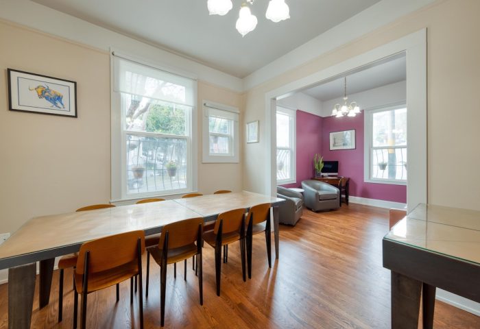 The Grove Inn, a gay-friendly hotel. Dining area with a long table and chairs. Living area with purple wall, chairs, and TV. LGBT travel.