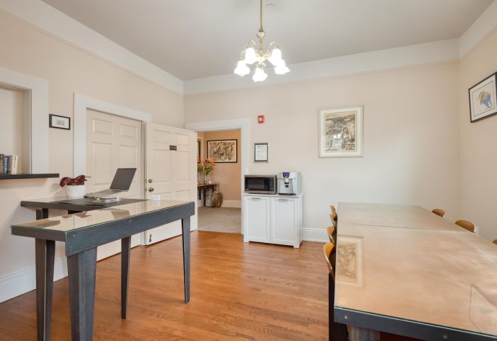 The Grove Inn, a gay-friendly hotel. View of a common area with tables, a desk with a laptop, and a microwave. Gay travel advice.