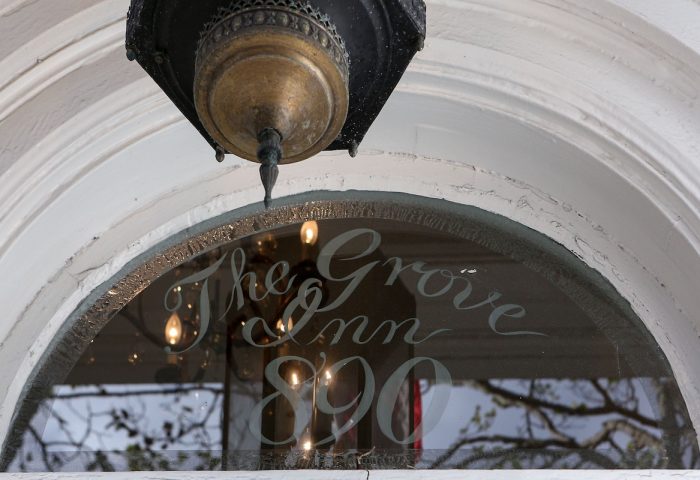 The Grove Inn sign on a window. A gay-friendly hotel, The Grove Inn is a great place for gay men to stay when traveling.