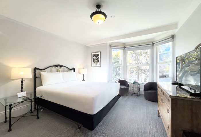 The Grove Inn gay-friendly hotel room. A well-lit bedroom with a large bed, sitting area, and TV. Great for gay men travel advice.