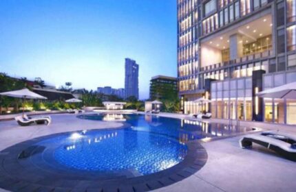 The Grove Suites by GRAND ASTON pool. Gay-friendly hotel with outdoor pool, lounge chairs, and city view. Luxury travel for gay men.